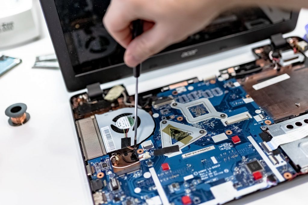 pexels photo 7639373 Hand repairing a laptop motherboard with a screwdriver, highlighting tech maintenance.